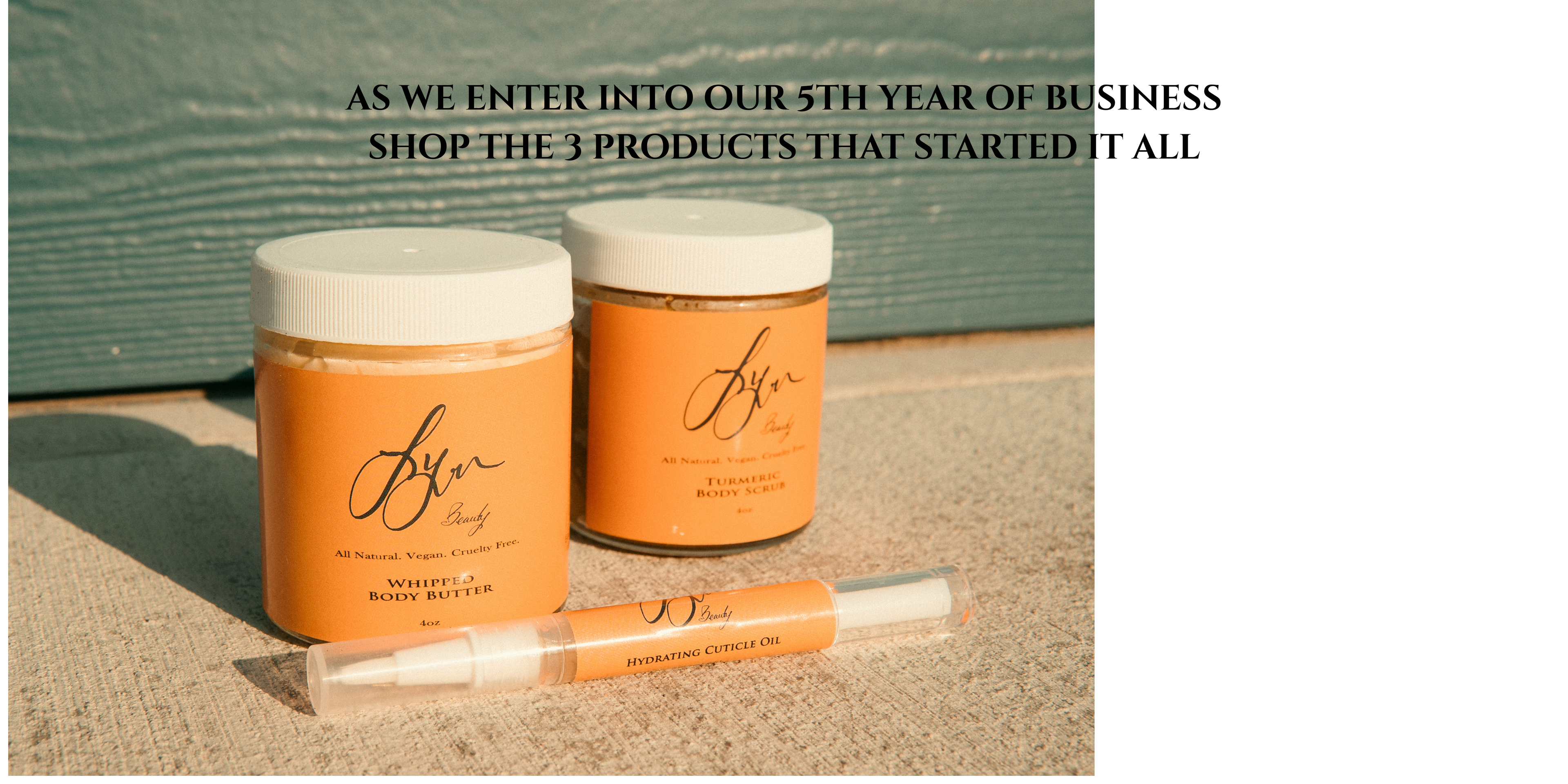 Two orange jars and a white tube with 'FYN' branding sitting on a textured surface.